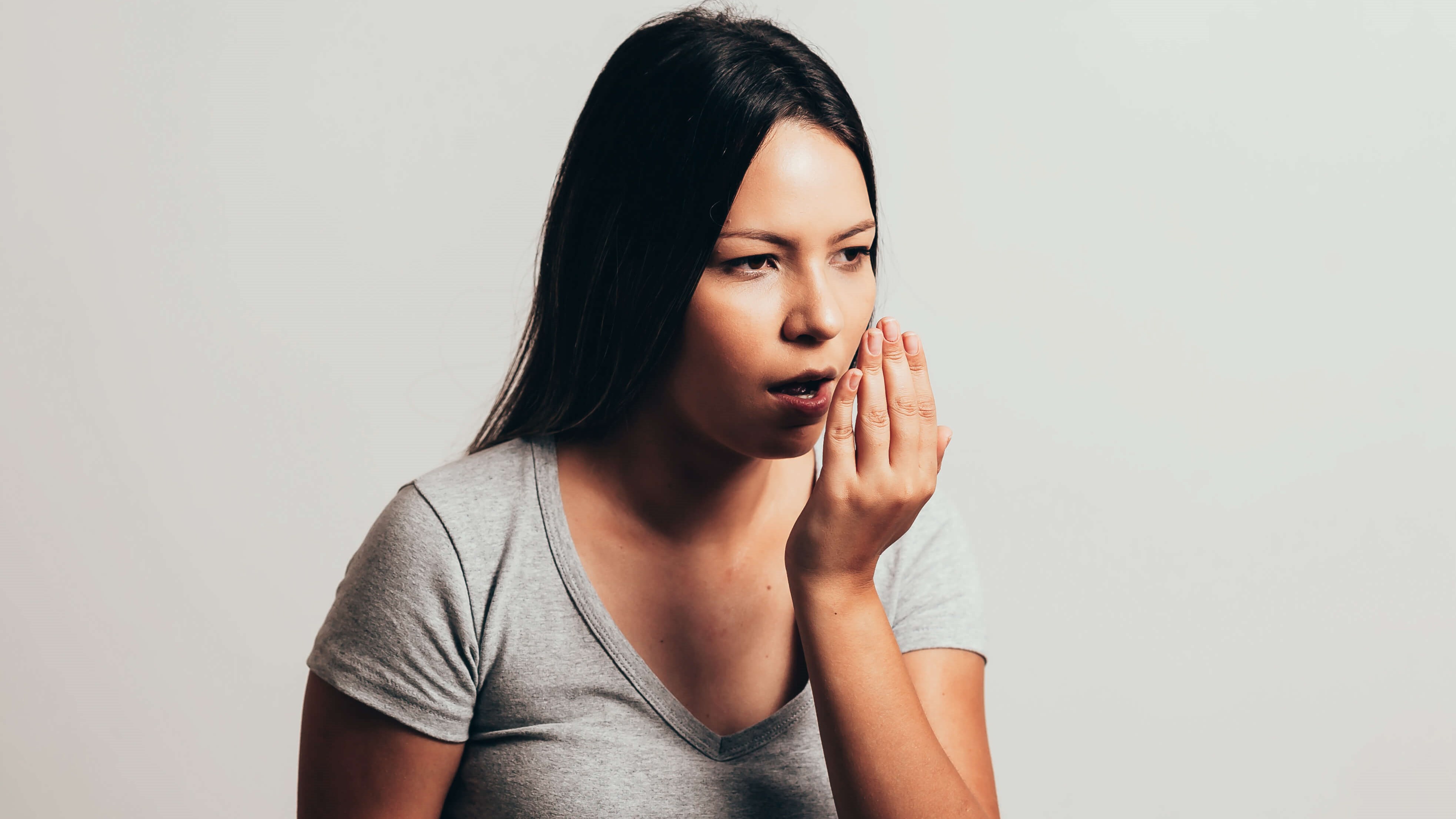 woman coughing into her hand p